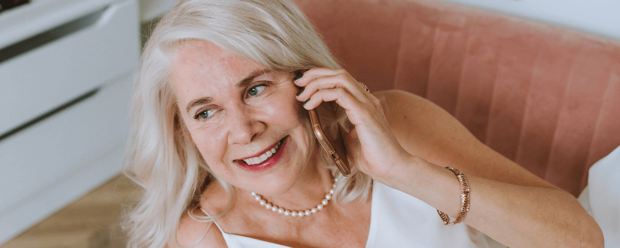 A woman with dental implants smiling towards the camera, showing her new white and straight smile.