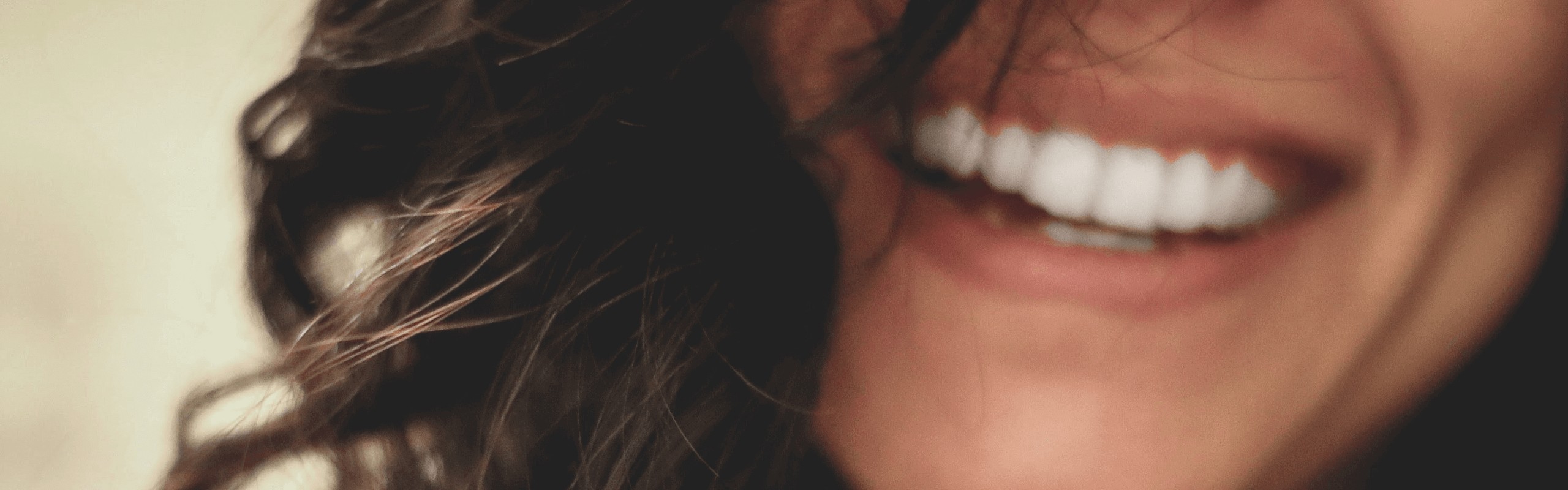 close up of brunette woman smiling with straight teeth results after Invisalign for a straighter smile