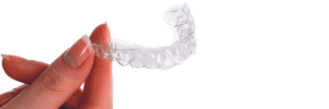 Holding Invisalign aligners towards the camera
