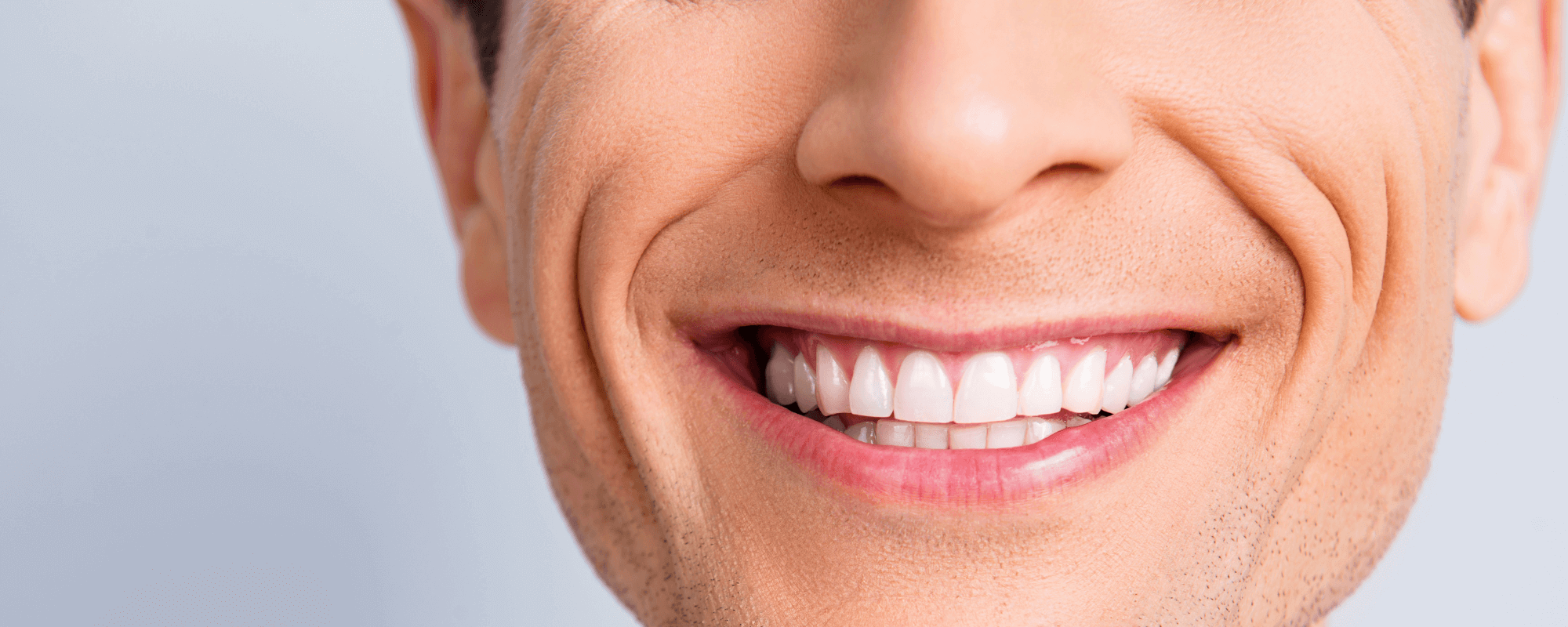 Man smiling with straight white teeth after having invisalign.