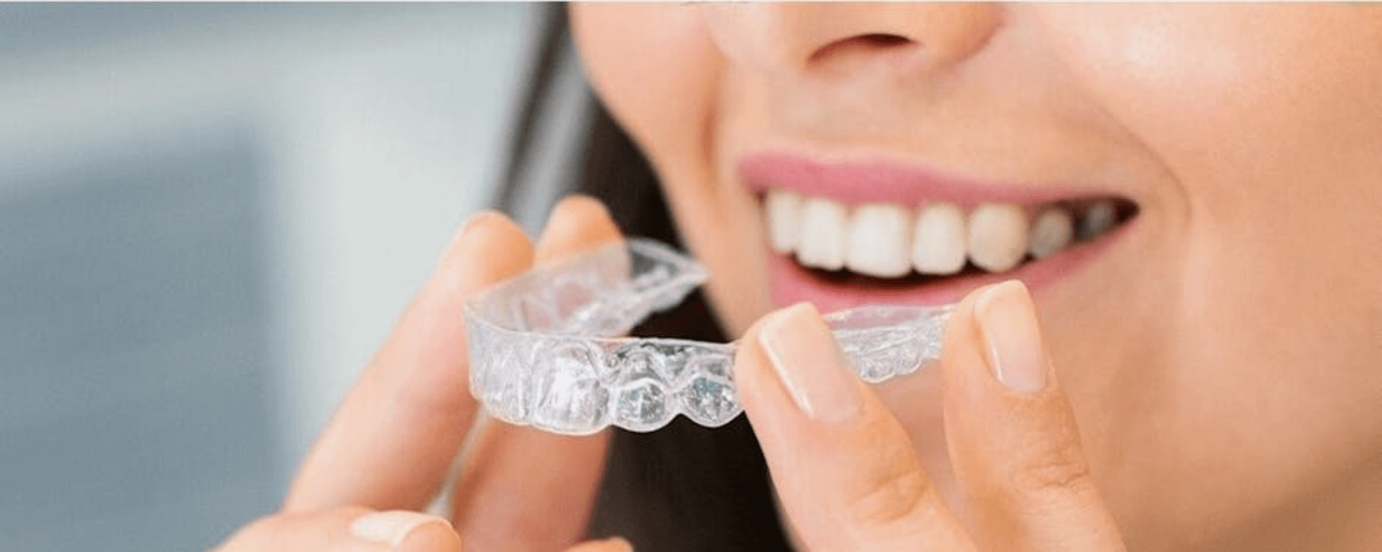 Woman holding invisalign aligners